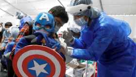 Un niño disfrazado de Capitán América recibe la vacuna contra la Covid en Bogotá. EFE/ Carlos Ortega