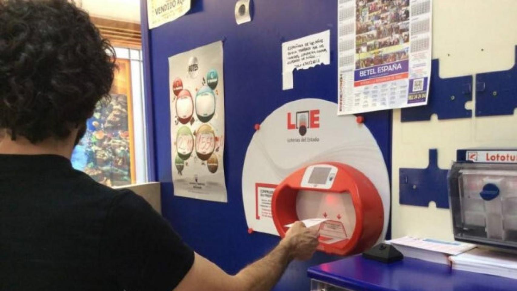 Un hombre echando la Bonoloto en una administración de Loterías