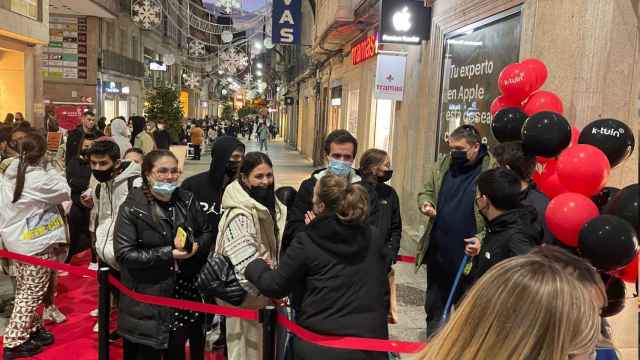 Gente esperando en la cola para entrar en la nueva tienda.