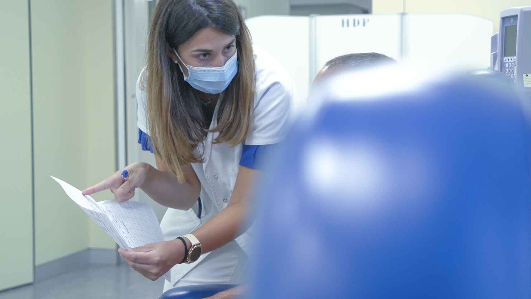 Una profesional sanitaria informa a un paciente.