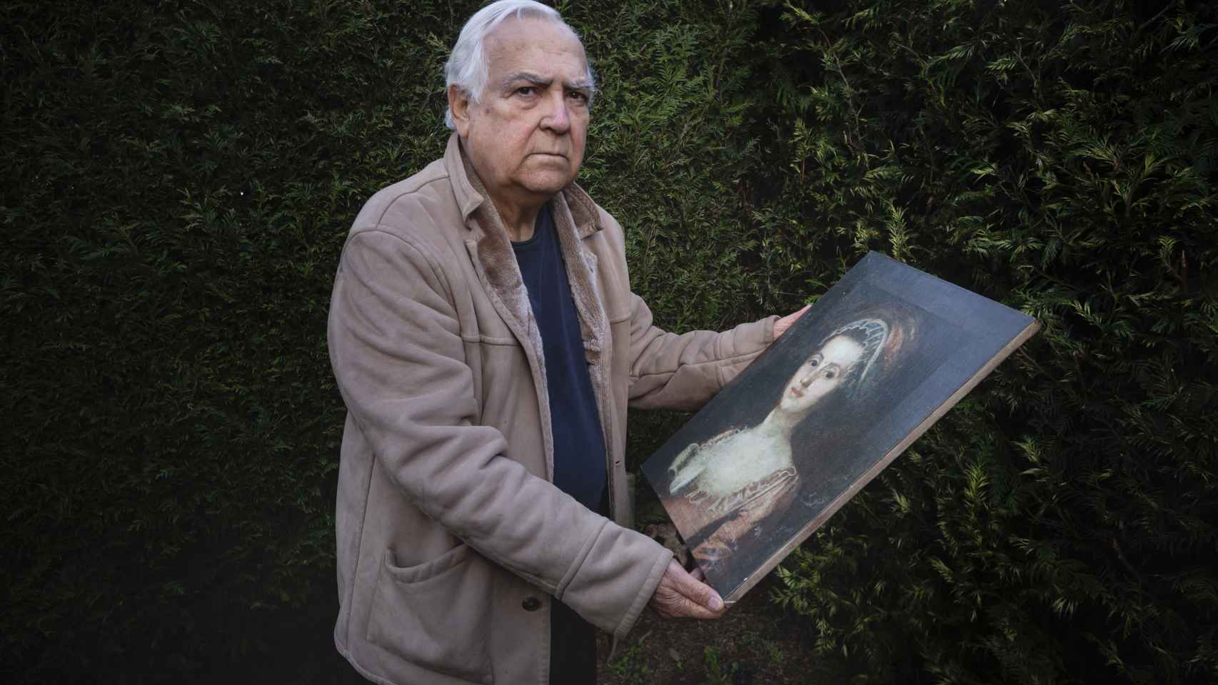 Santos, en su casa de Oleiros, posa con la réplica del cuadro robado.