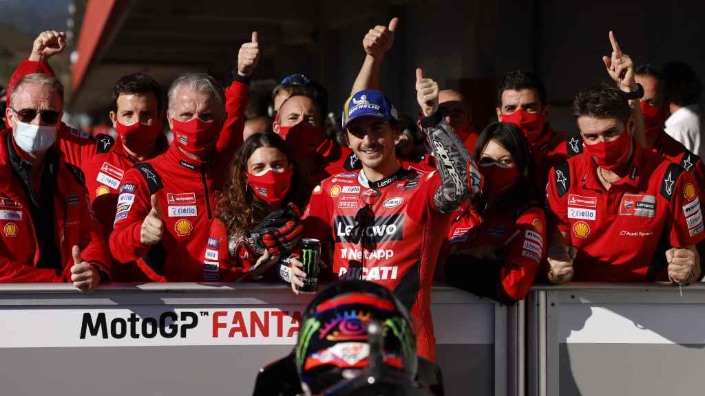 Pecco Bagnaia, rodeado de los miembros de su equipo, celebra la pole lograda en Portimao.