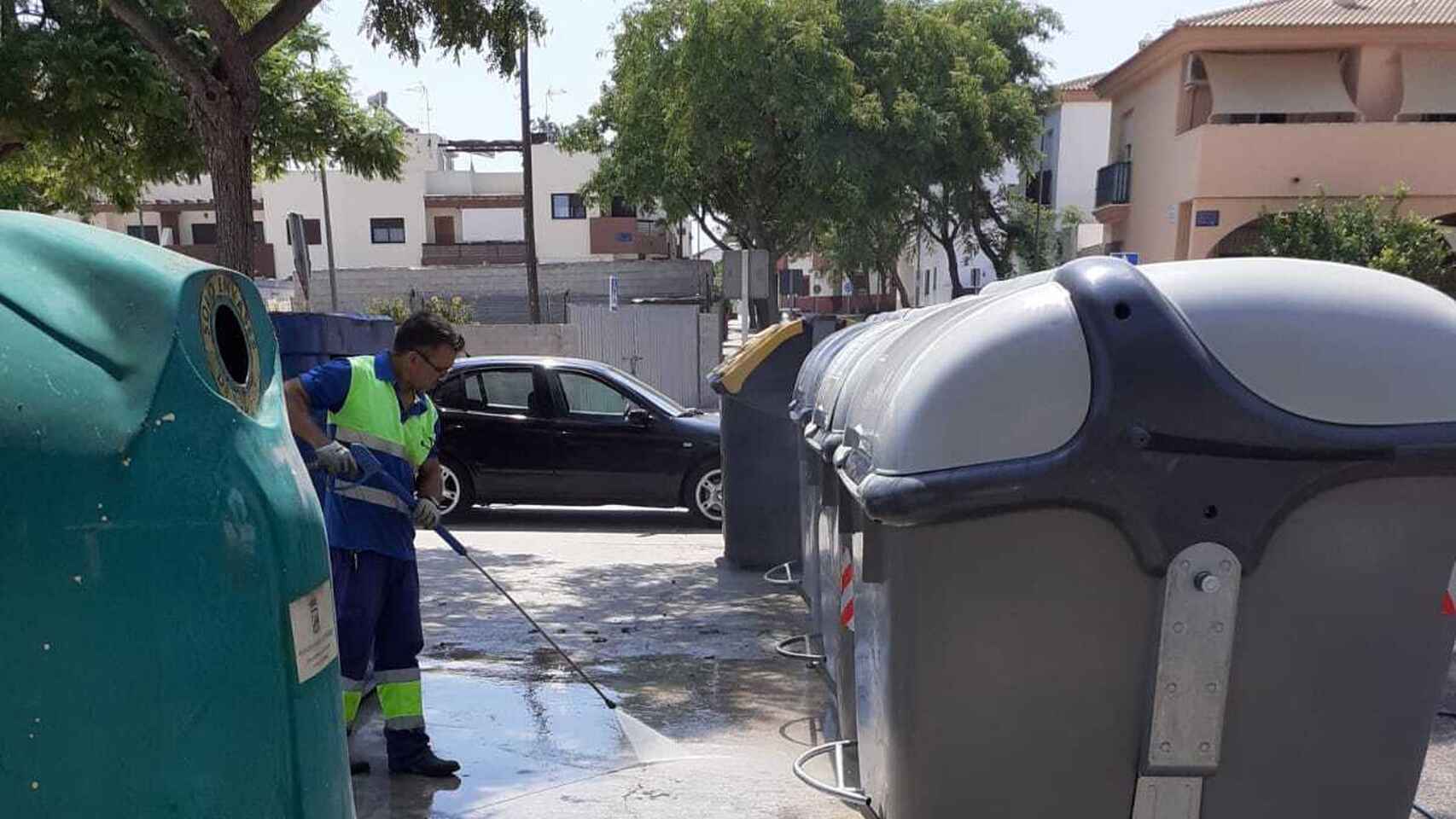 Un trabajador de Limasam, junto a unos contenedores de basura en Málaga.