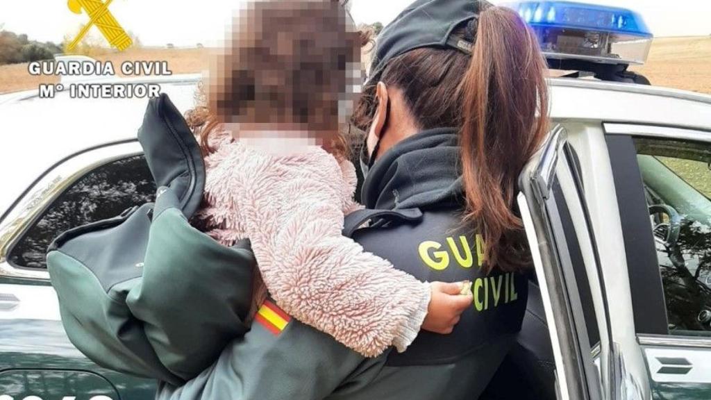 Una agente de la Guardia Civil sostiene a la niña momentos antes de entregársela a sus padres