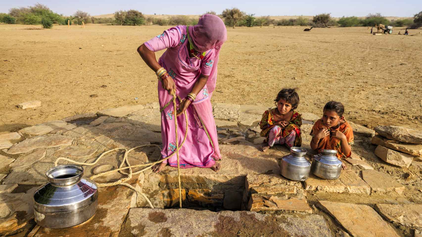 Mujer india cogiendo agua de un pozo