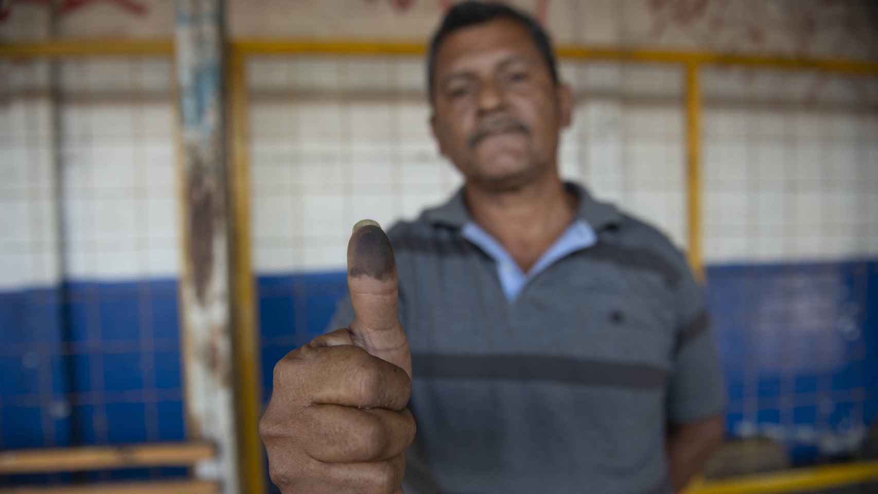 Un hombre muestra su dedo pulgar con tinta tras votar en Managua, Nicaragua.