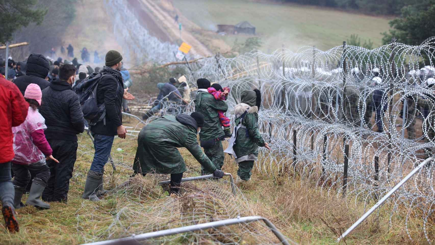 Inmigrantes, entre ellos mujeres y niños, intentan cruzar la frontera hacia Polonia en la región de Grodno.