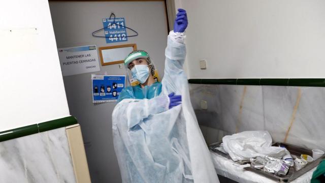 Un sanitario colocándose un equipo de protección contra la Covid, en imagen de archivo.