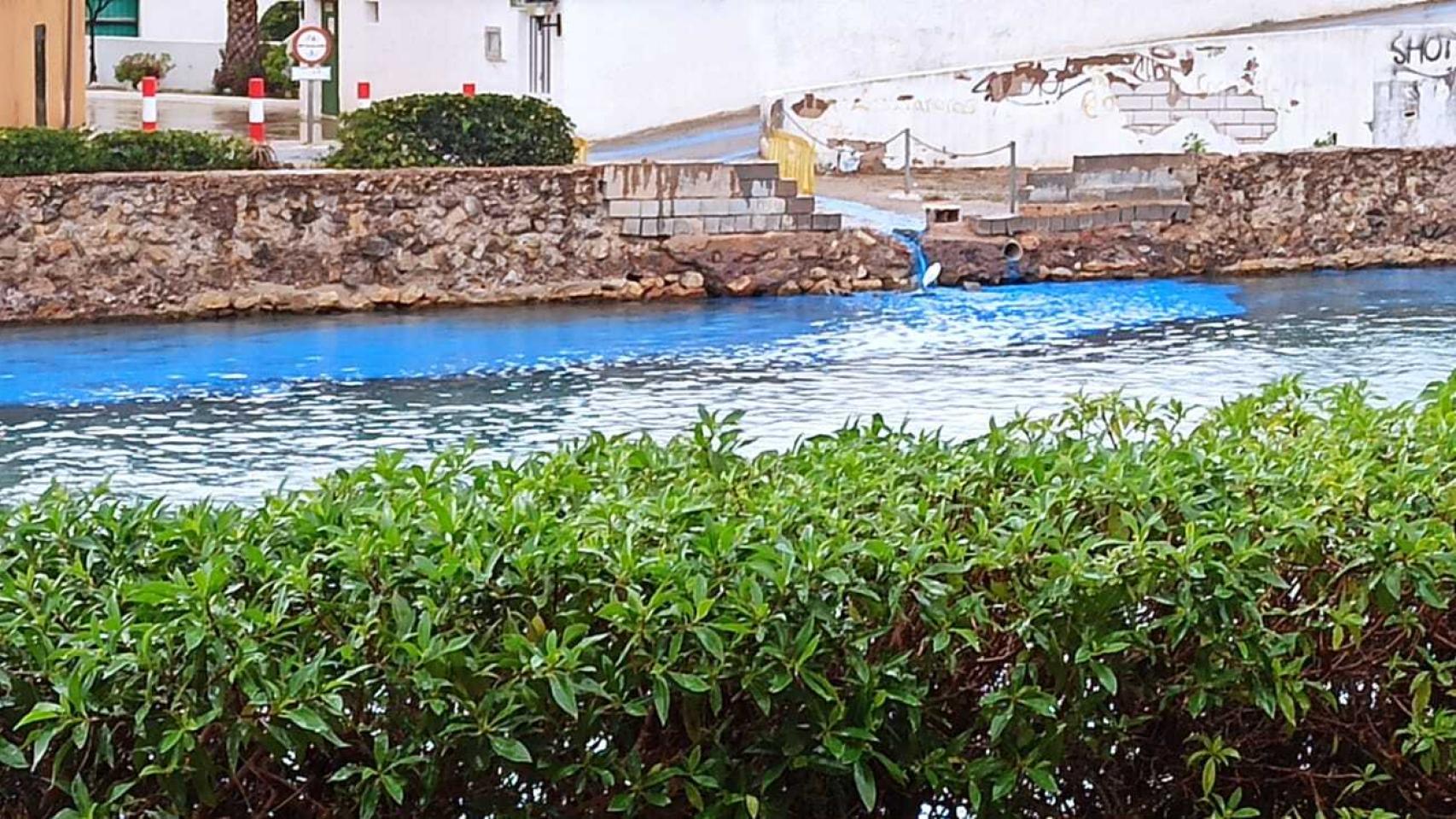El agua del Mar Menor teñida de azul en La Manga por un arrastre de pintura.