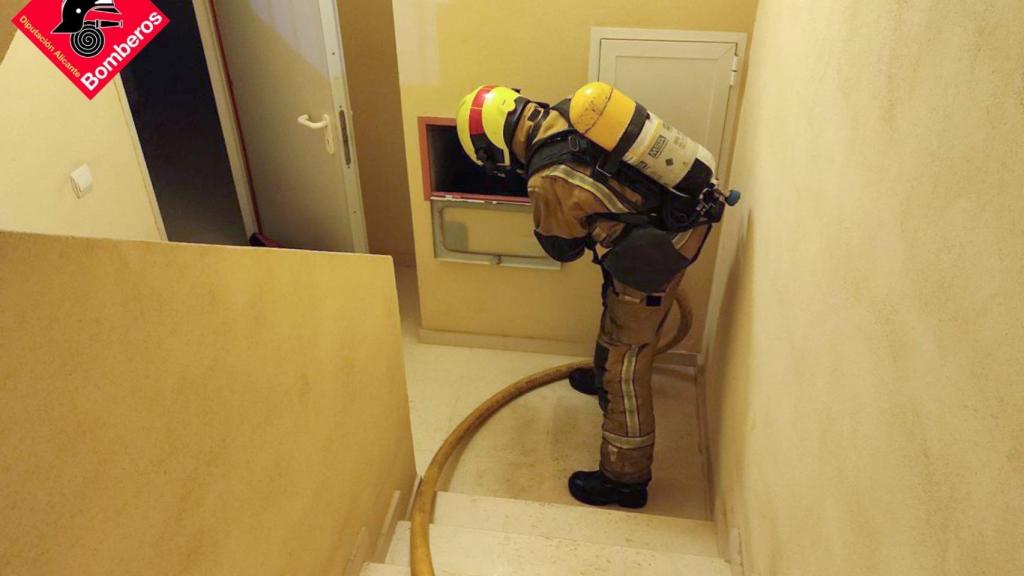 Uno de los bomberos, dentro del rascacielos,  utilizando la columna seca.