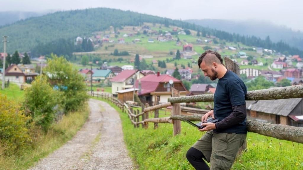 Un joven utilizando su teléfono móvil a las afueras de una localidad de la España Vaciada