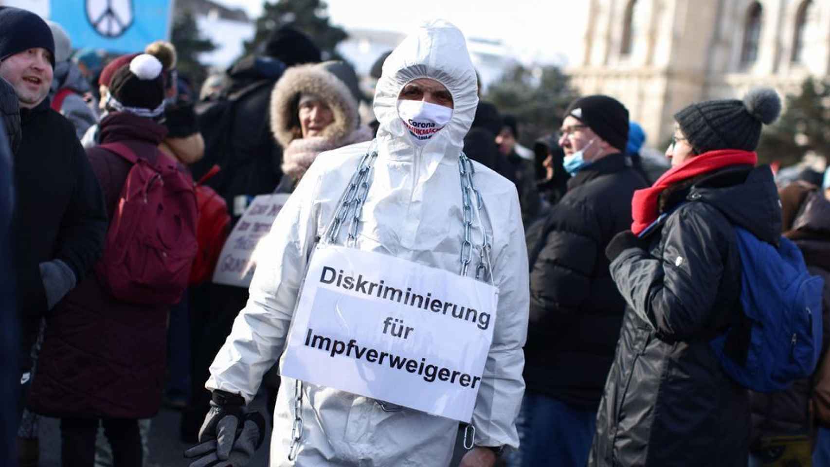 Un hombre durante una manifestación en Viena con un cartel que pone discriminación a los que rechazan las vacunas.