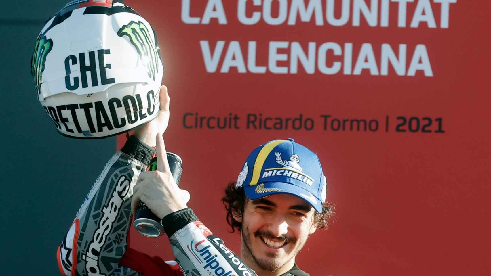 Pecco Bagnaia levanta el casco  que Valentino Rossi lució en Phillip Island 2004, tras proclamarse campeón.