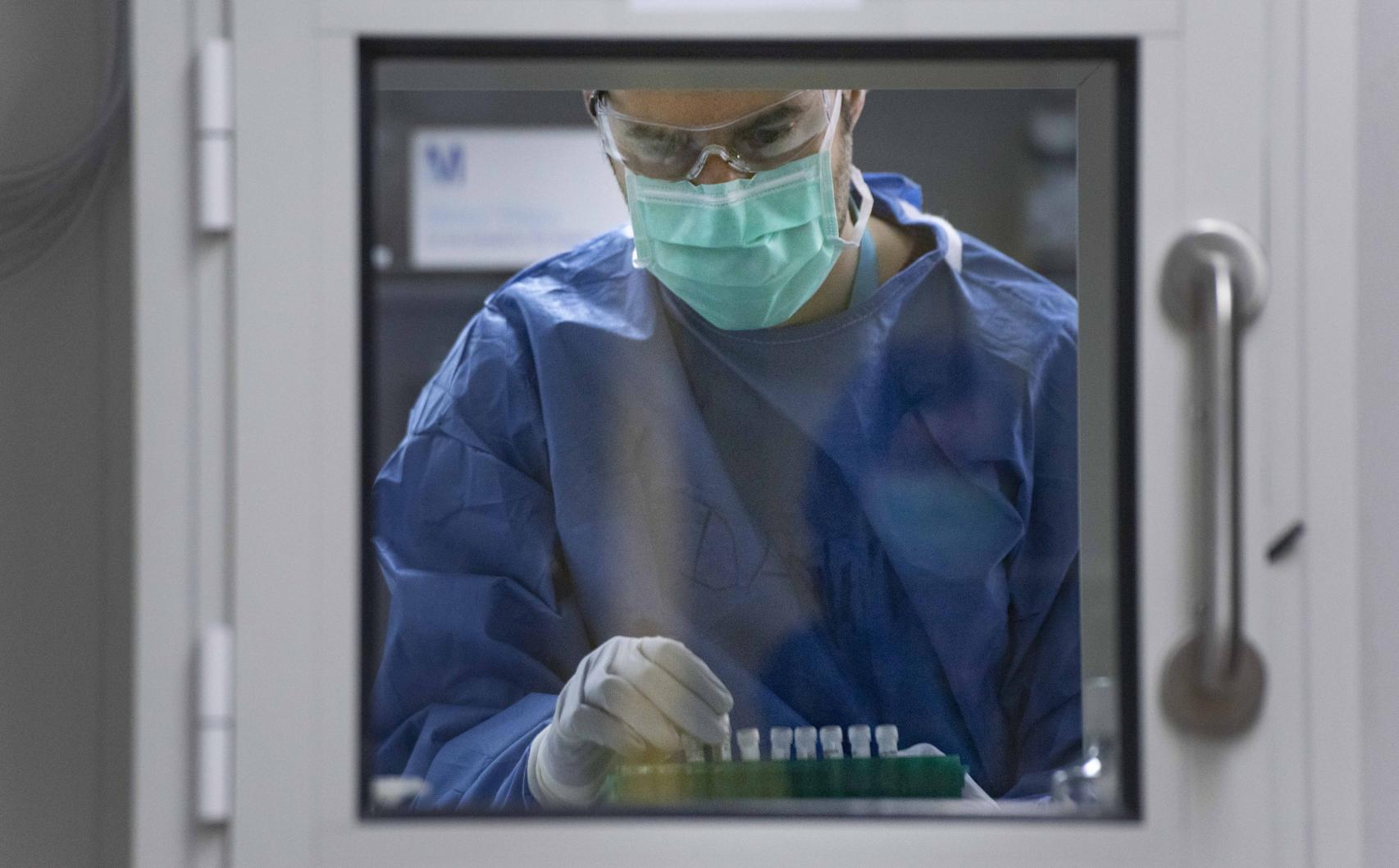 Un investigador recoge unas muestras en el laboratorio de bioseguridad de nivel 3 de IrsiCaixa.