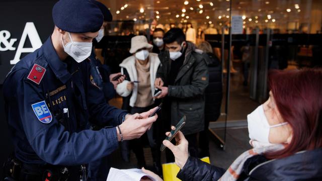 Un policía pide a una mujer en Viena el certificado Covid para acceder a una tienda.