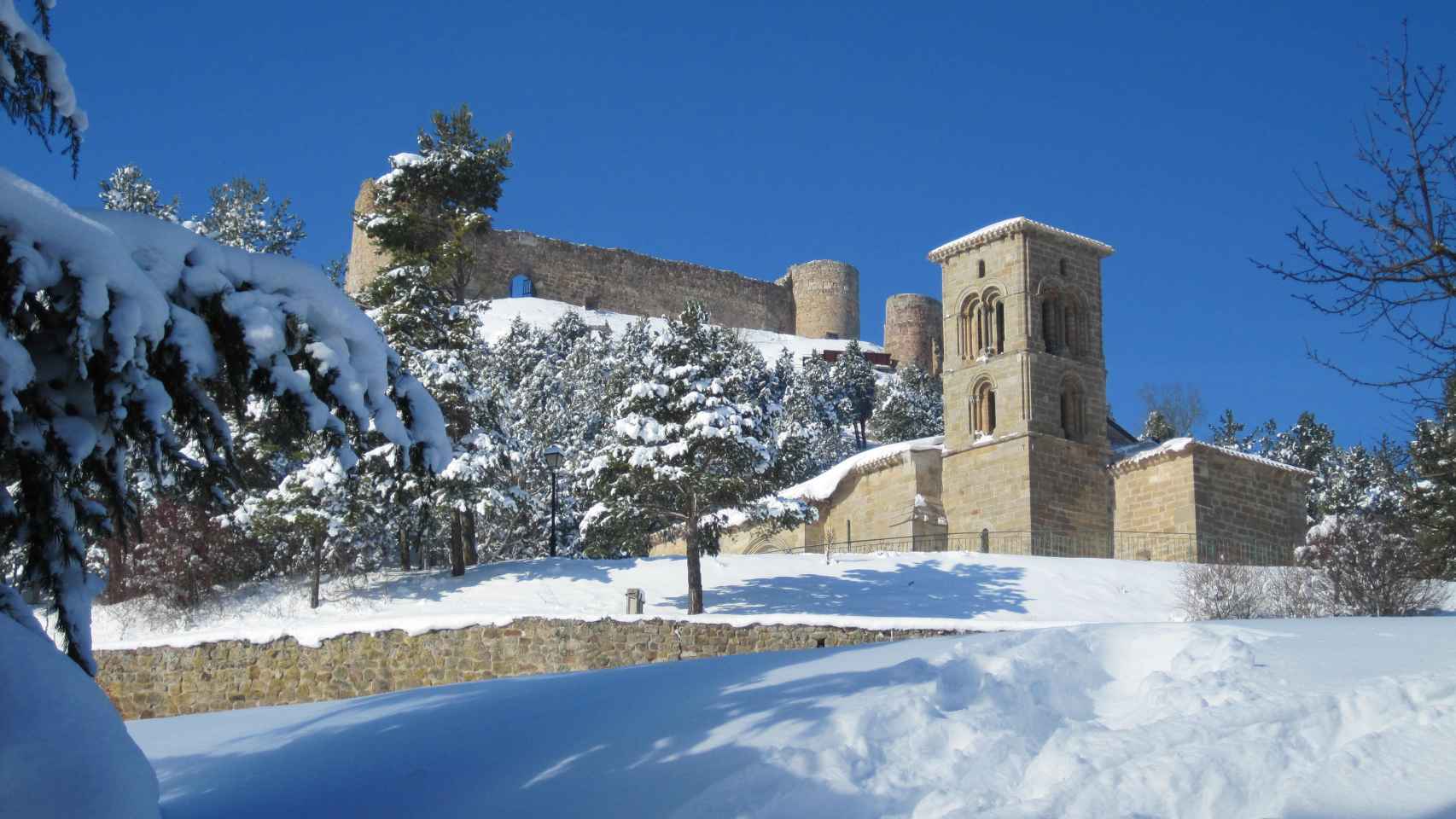 Bella estampa invernal del conjunto que forman la iglesia de Santa Cecilia y el castillo