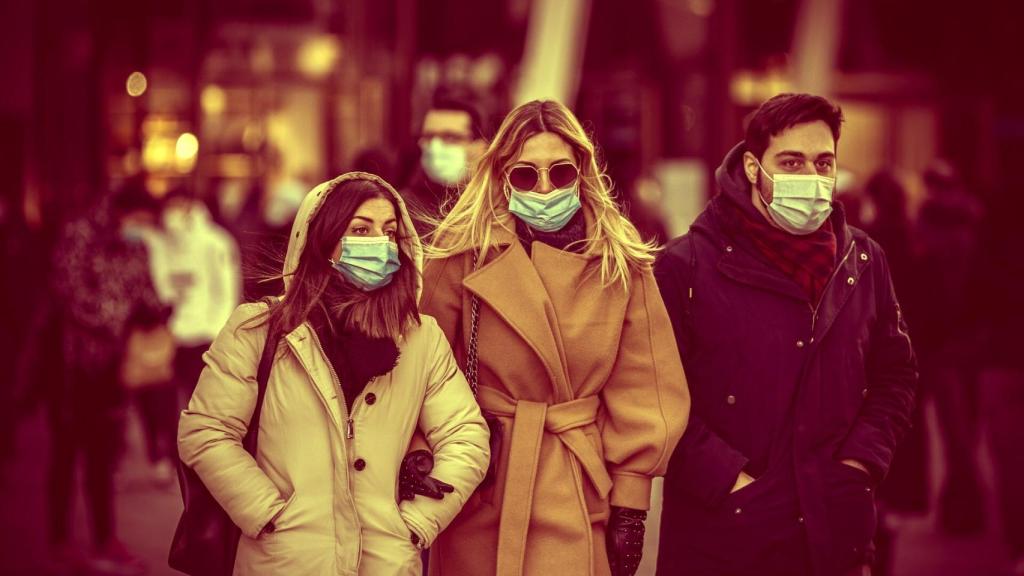 Tres amigos paseando con la mascarilla puesta.