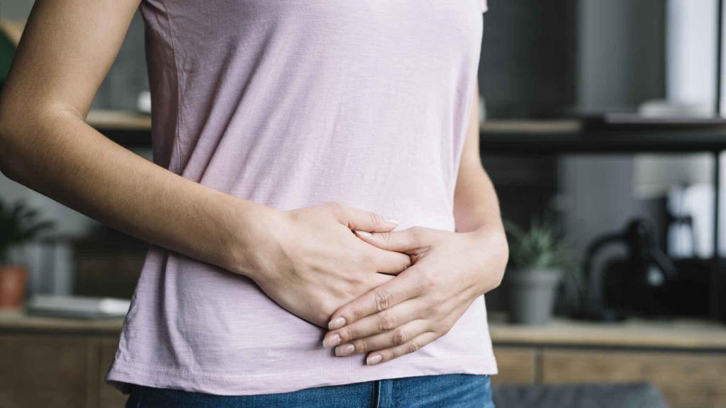 Una mujer sitúa sus manos sobre el vientre.