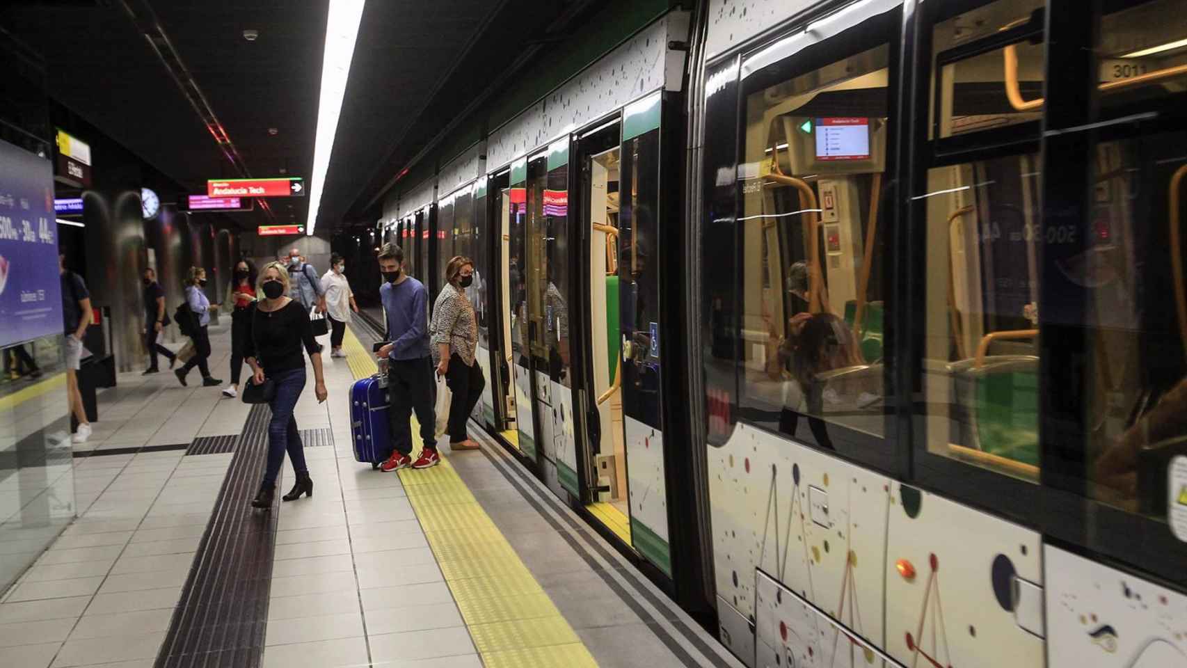 Varios pasajeros salen de uno de los trenes del Metro de Málaga.