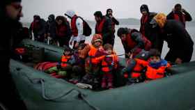 Decenas de inmigrantes embarcan una embarcación inflable en la costa francesa para dirigirse al Reino Unido.
