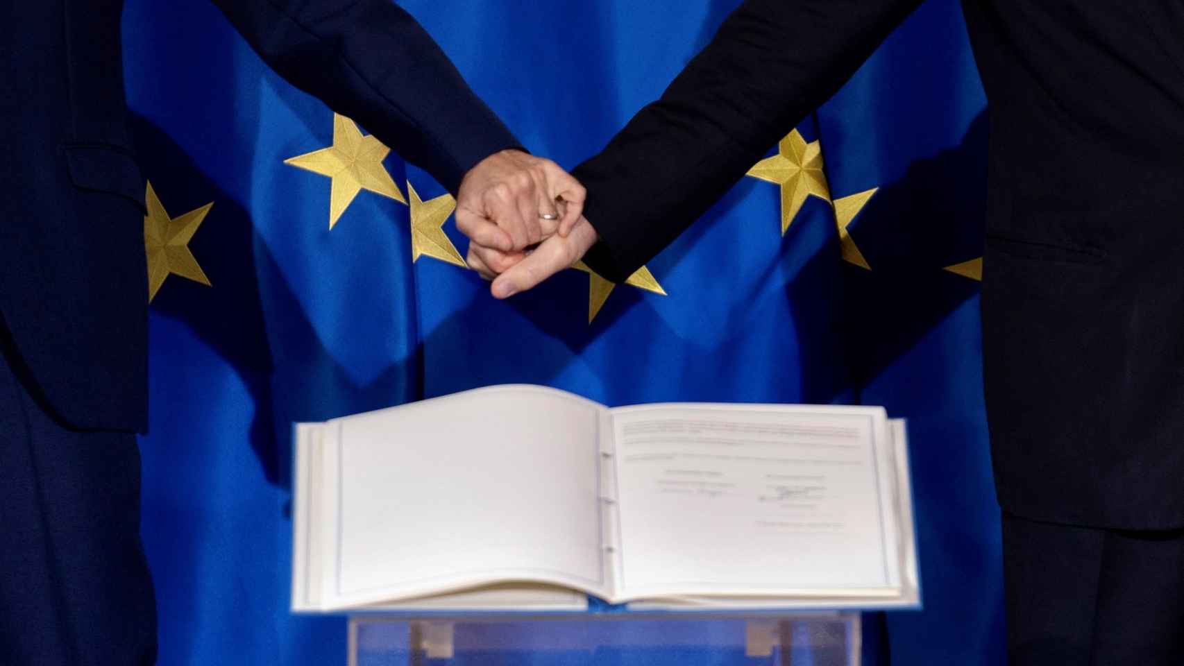 Macron y Draghi estrechan sus manos tras la firma.