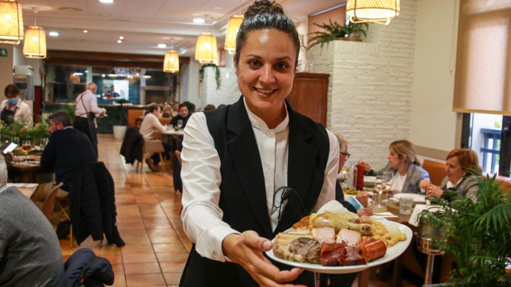 Beatriz, jefa de sala de La Parrilla de Arganda, posa con la bandeja del segundo plato del cocido madrileño.