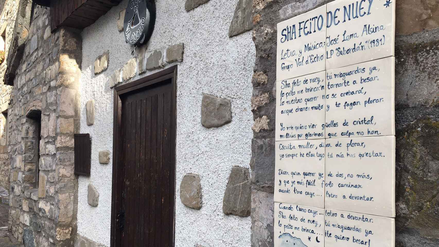 Poema escrito en cheso sobre la fachada de un edificio en Hecho (Huesca).