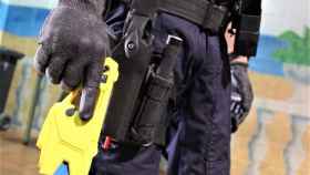 Un agente policial con una pistola táser en la mano.