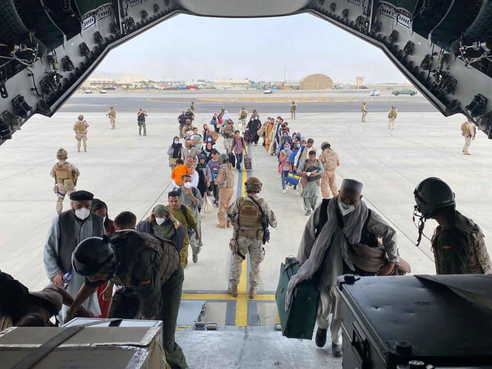 Ciudadanos afganos suben a un avión del Ejército español durante la evacuación desde el aeropuerto de Kabul.