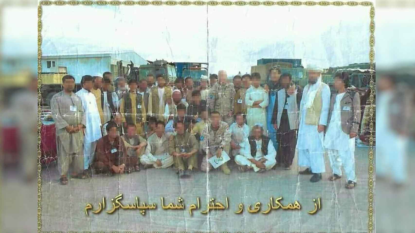 Foto impresa en la que aparece Hasan, que trabajaba en la base, junto a soldados españoles.