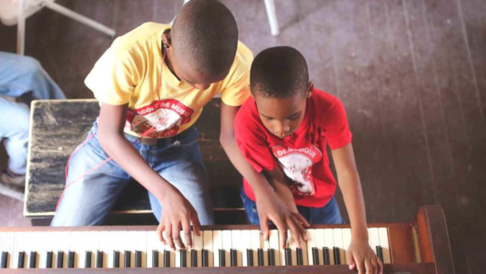 Dos niños haitianos tocando el piano.
