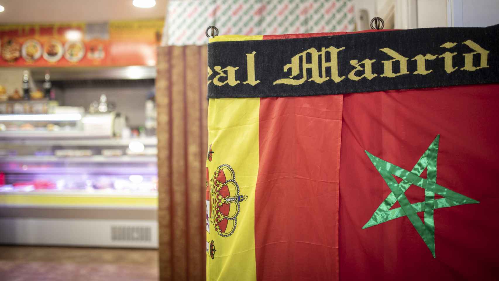 Las banderas de España y Marruecos bajo una bufanda del Real Madrid.