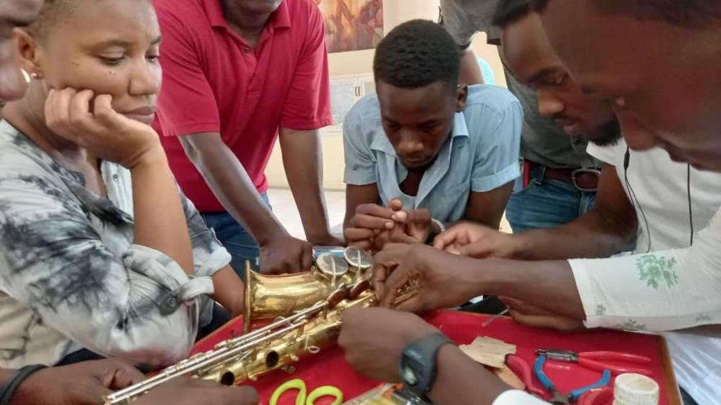 Jóvenes haitianos reparando sus instrumentos.