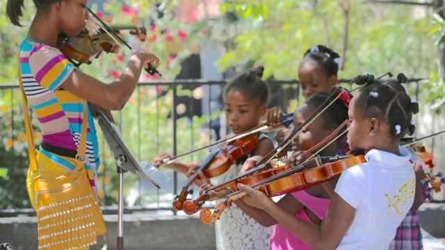 La profesora de música Anne Ludia dando clases de violín a niñas de Haití.