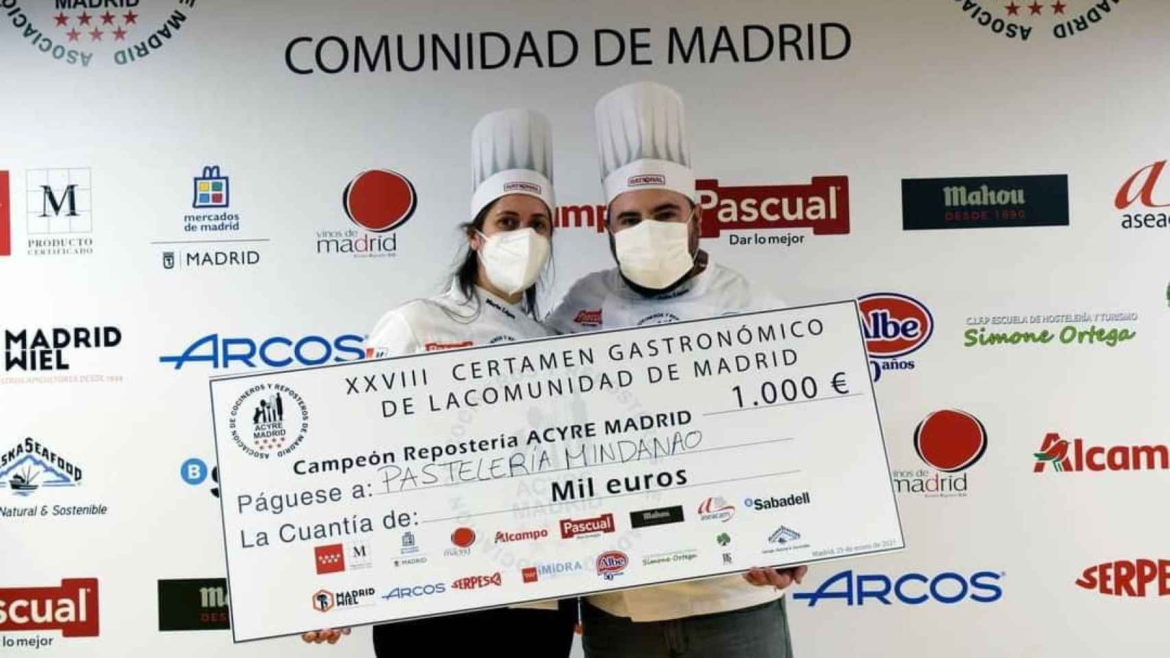 Los hermanos López, de Mindanao, posan con un cheque de 1.000 euros por ganar el Certamen Gastronómico de la Comunidad de Madrid.