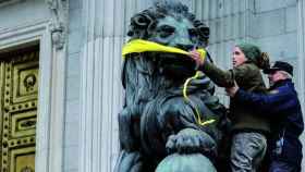 Un joven trata de amordazar a un león del Congreso.