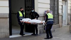 Operarios del retén fúnebre sacan el cadáver de Cristina, de 30 años de edad.