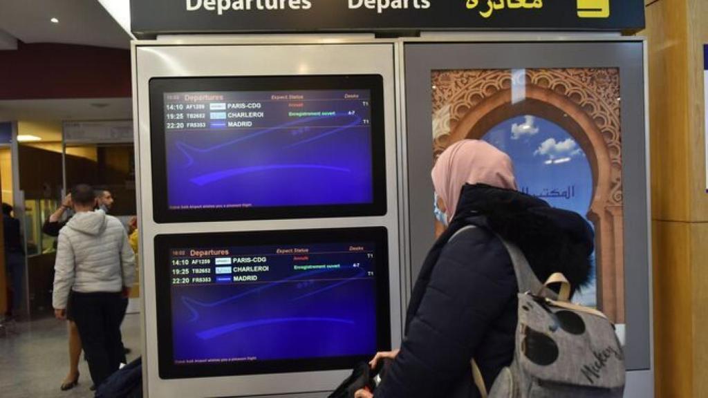 Una mujer observa un panel de vuelos en el aeropuerto de Rabat.