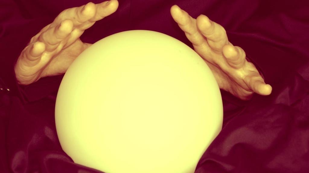 Las manos de una clarividente sobre una bola de cristal.