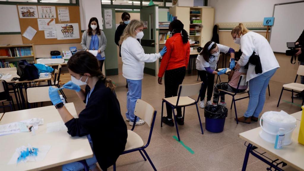 Personal sanitario vacuna a dos menores de 12 años  en un colegio valenciano.