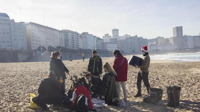 Voluntarios participando en la limpieza de la playa del Orzán