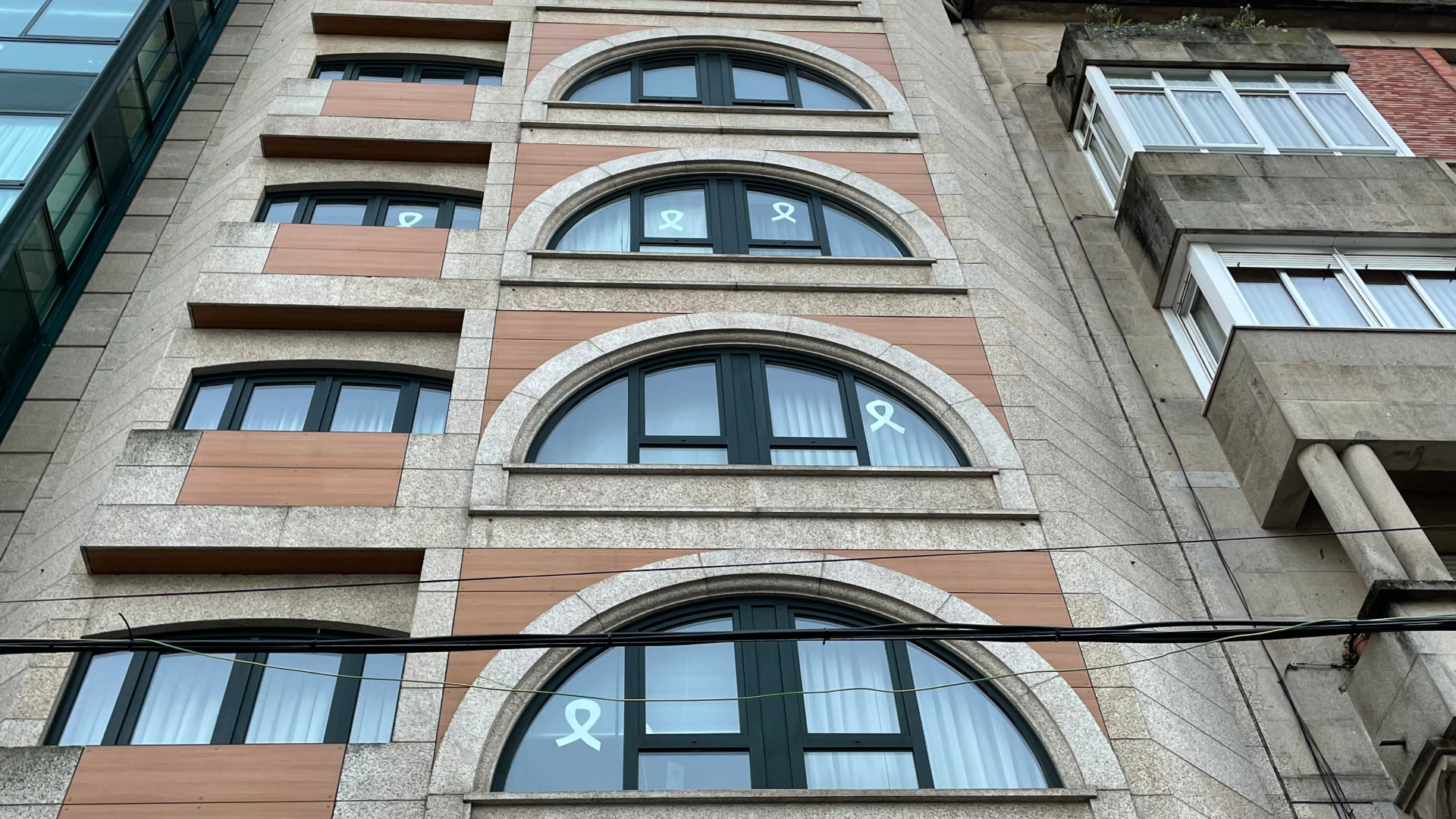 Lazos blancos en las ventanas de un edificio de Rosalía de Castro. Foto: Treintayseis