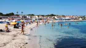 Decenas de personas disfrutan del sol en la playa de Punta Prima (Menorca).