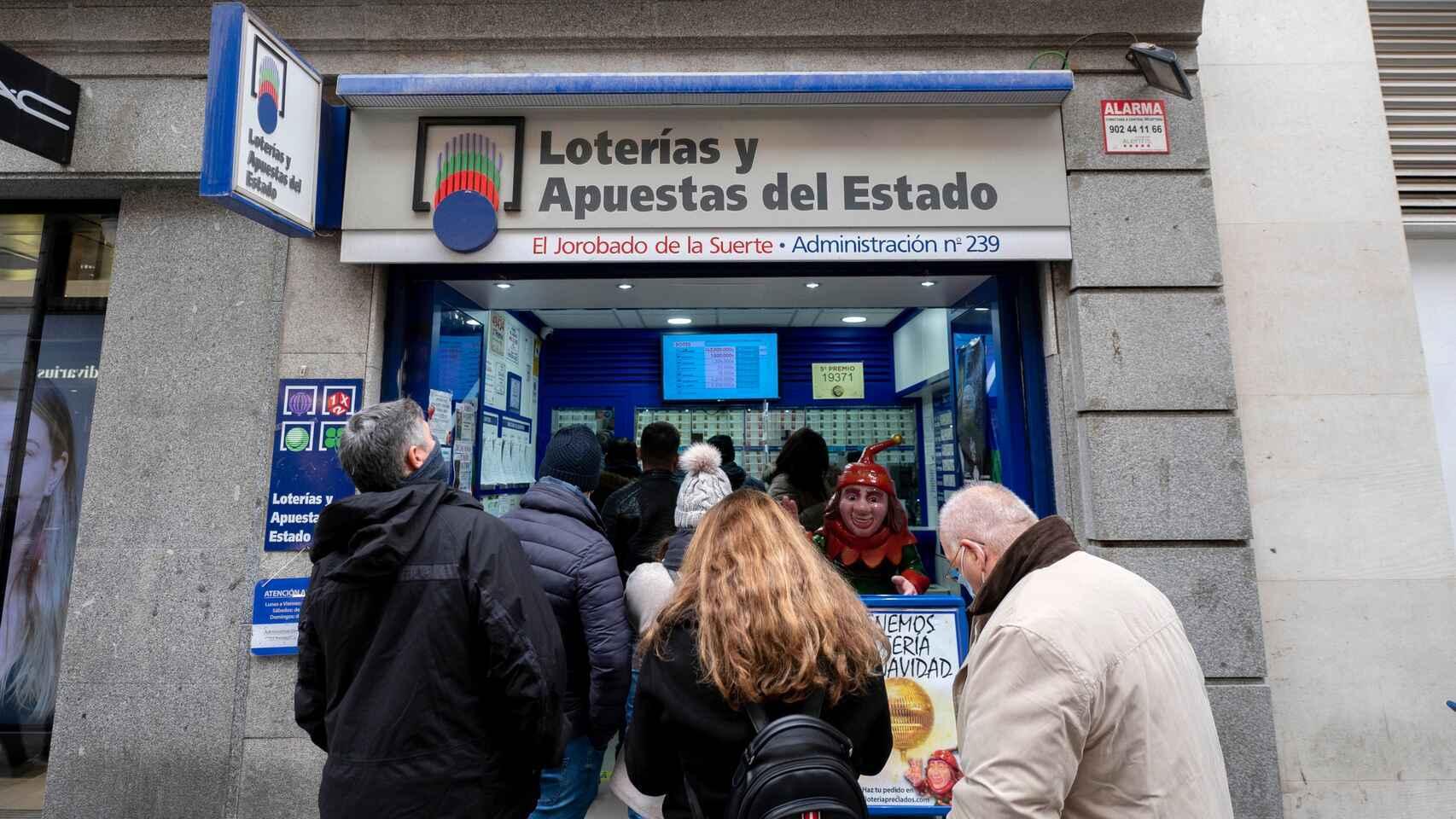 Personas haciendo cola en una Administración de Loterías y Apuestas del Estado