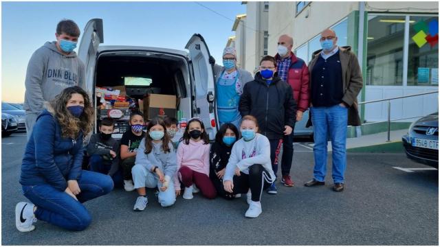 Alumnado posando frente a la furgoneta cargada de alimentos.