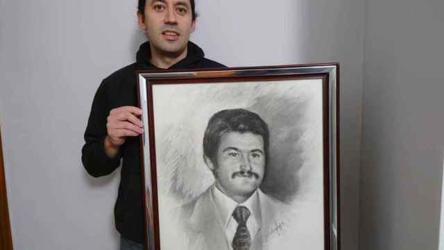 Juan José Tauste sujeta un cuadro con la cara de su padre.