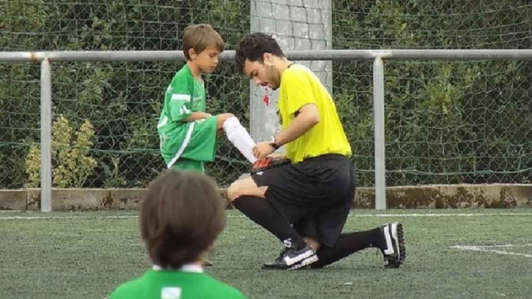 Lucas Vicente Vidal, árbitro fallecido, ayudando a un niño a atarse los cordones durante un partido