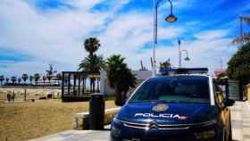 Coche Policía Nacional en paseo marítimo junto a playa Málaga.