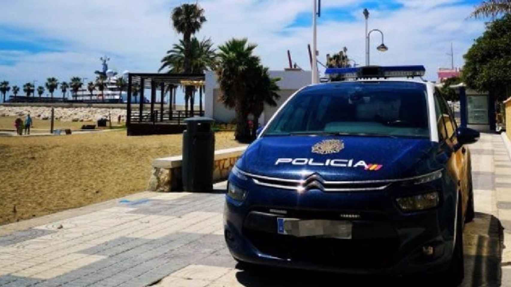 Coche Policía Nacional en paseo marítimo junto a playa Málaga.