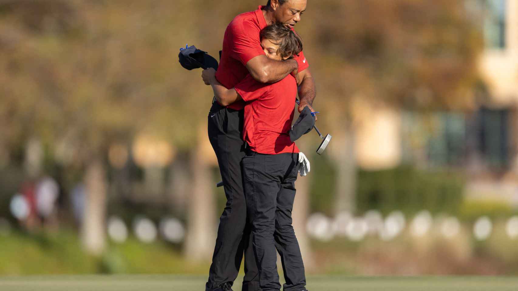 Abrazo entre Tiger Woods y su hijo Charlie, durante un torneo de golf